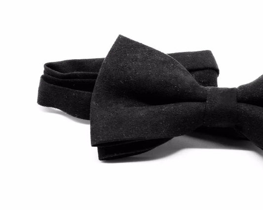 Pajarita negra de tela con diseño elegante y acabado artesanal sobre fondo blanco