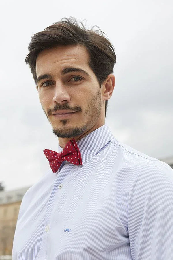 Hombre joven con camisa blanca de rayas y pajarita roja con diseño original hecho a mano en España